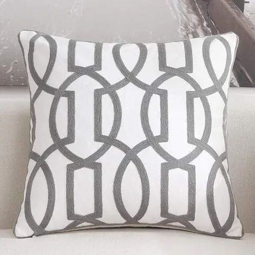 Housse de coussin brodée géométrique
